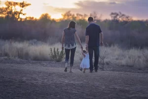Happy family walking together outdoors smiling parents and children