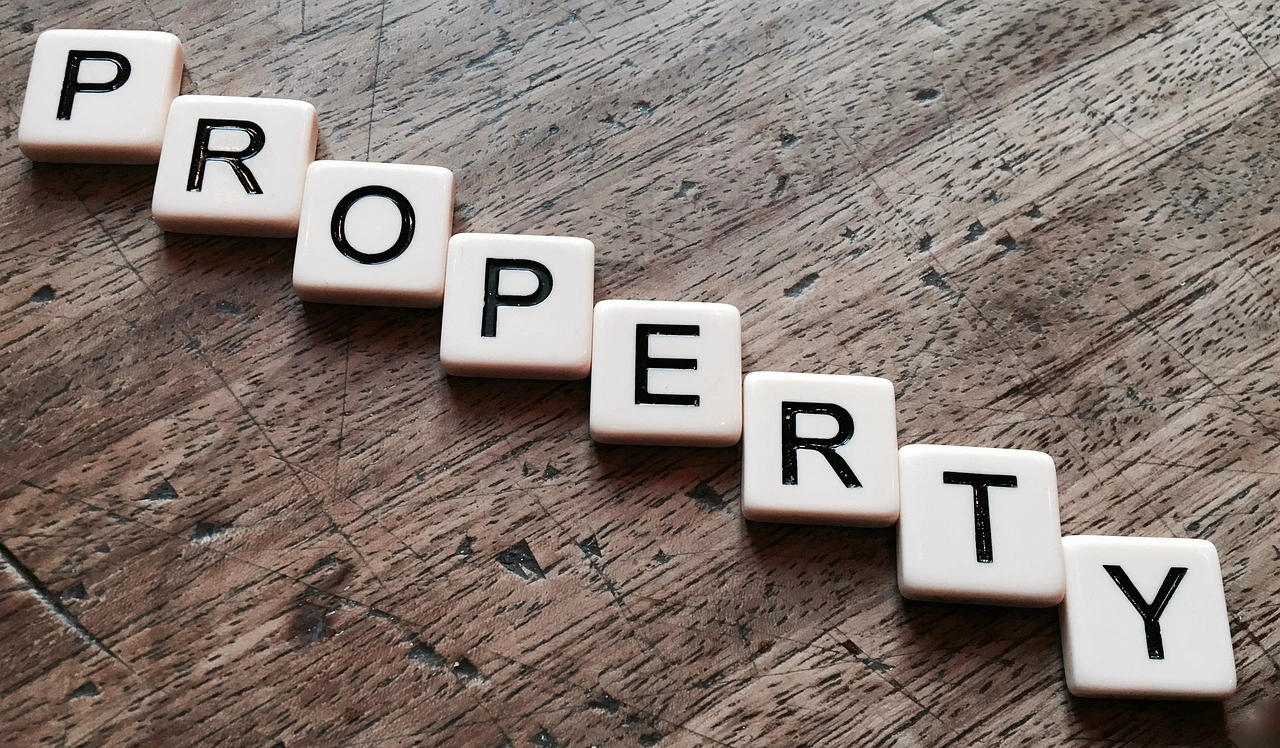 Word “property” spelled out with letter tiles on a wooden surface