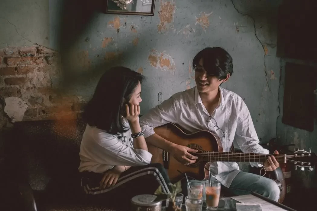 A young unmarried couple enjoying a romantic moment with a guitar, representing partners who are legally vulnerable and need a will to ensure inheritance rights in malaysia.