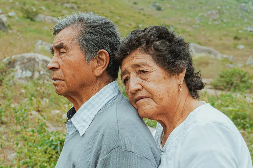 An affectionate elderly husband and wife, with the wife hugging her husband from behind, symbolizing the love and legacy that parents want to protect through proper estate planning in malaysia.