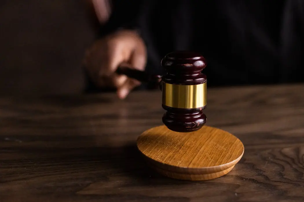 A close-up of a judge striking a wooden gavel, representing the high court legal proceedings required to obtain a grant of probate in malaysia.